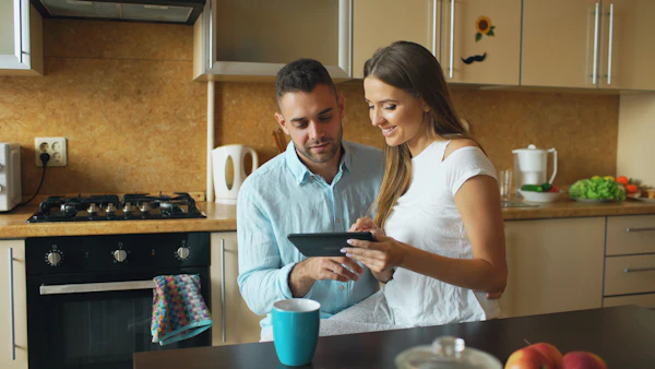 Couple regardant tablette dans la cuisine moderne