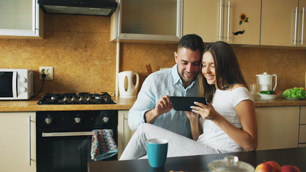 Couple regardant une tablette dans une cuisine