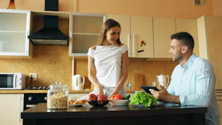 Couple preparing food together in a modern kitchen.