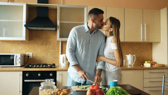 Couple kissing while preparing food in kitchen