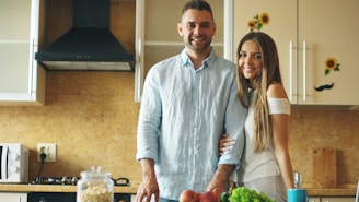 A smiling couple standing in a modern kitchen.