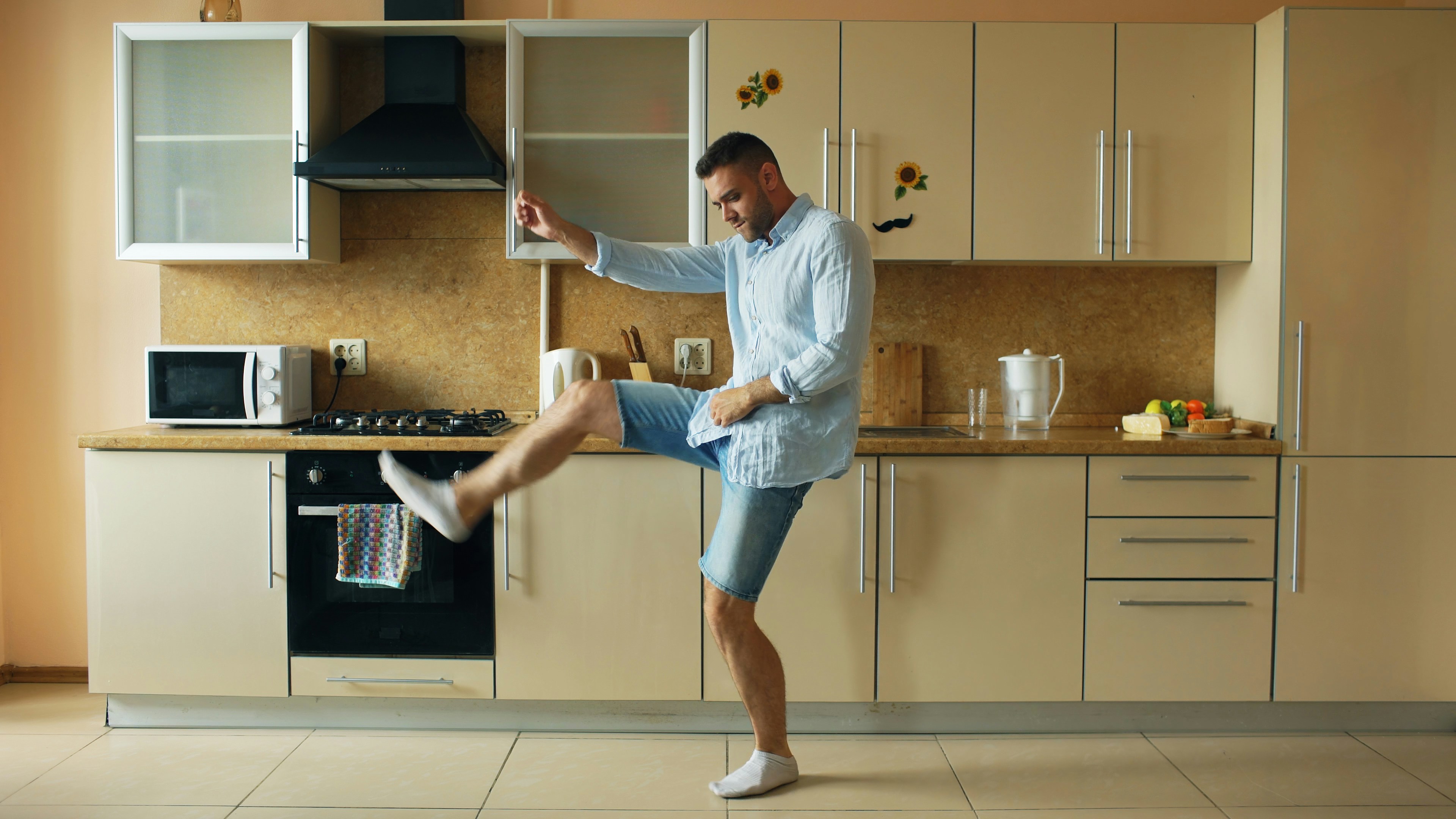 Homme dansant énergiquement dans une cuisine moderne.
