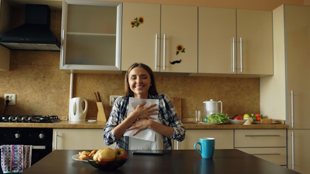 Woman hugging papers in a kitchen