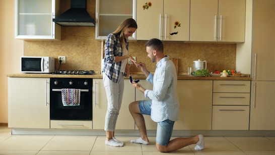 Man proposes to woman in a kitchen.