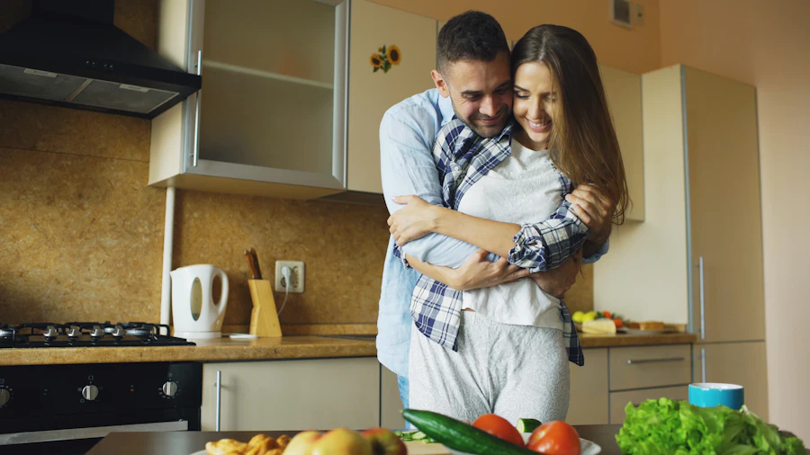 Casal adulto sorrindo em uma cozinha iluminada
