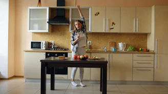 Young woman dancing in a modern kitchen.