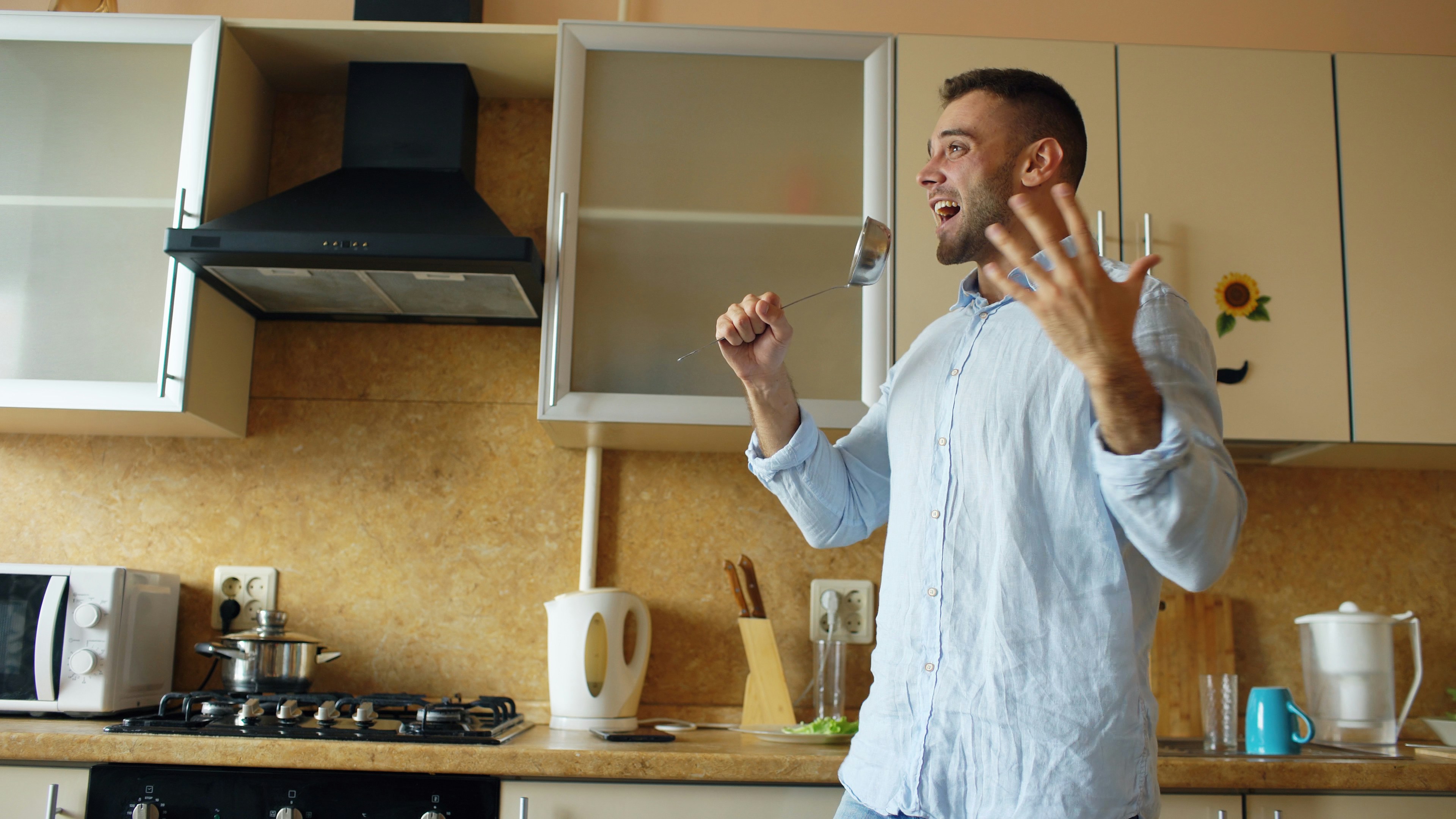 Man dancing and singing in a kitchen