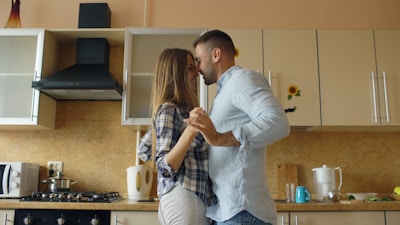 Couple dancing and kissing in a kitchen.