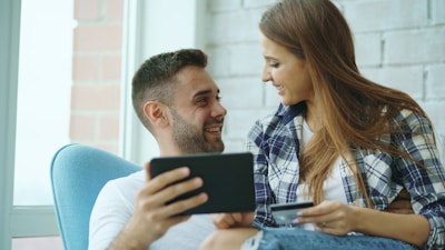 Couple looking at tablet while holding credit card