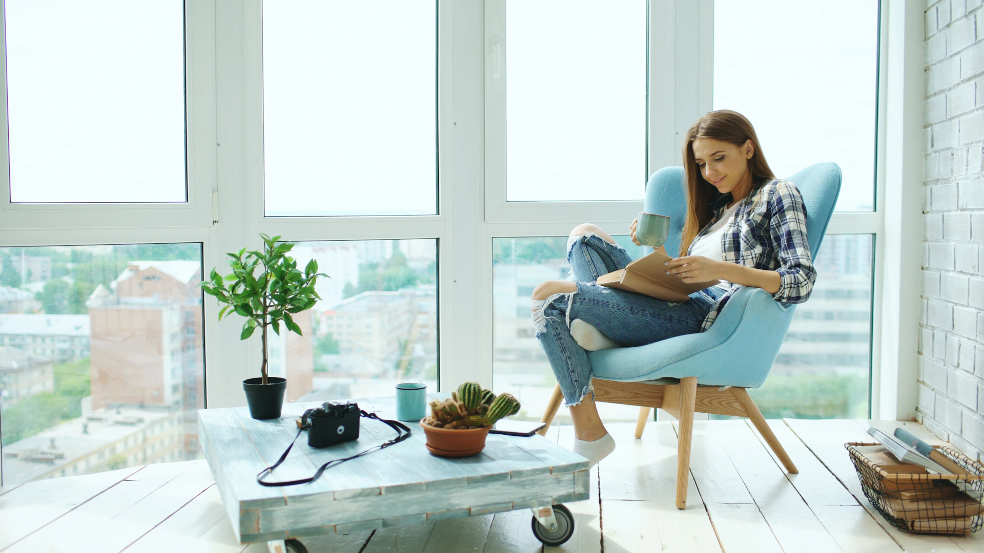Woman reading a book in a chair by window