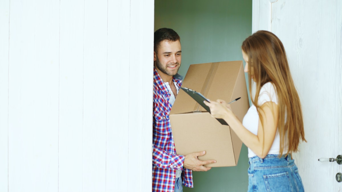 Couple signing for a package delivery at their door
