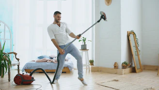 Man playing vacuum cleaner like a guitar