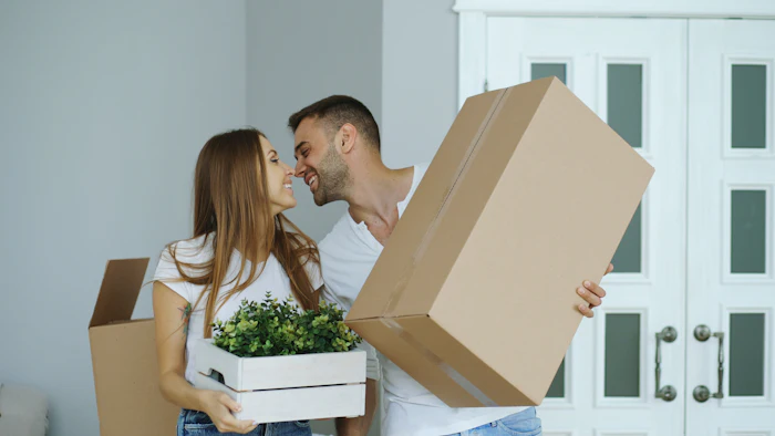 Happy couple moving out with boxes
