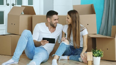 Couple looking at tablet surrounded by moving boxes