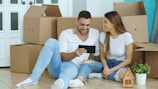 Couple looking at tablet surrounded by moving boxes