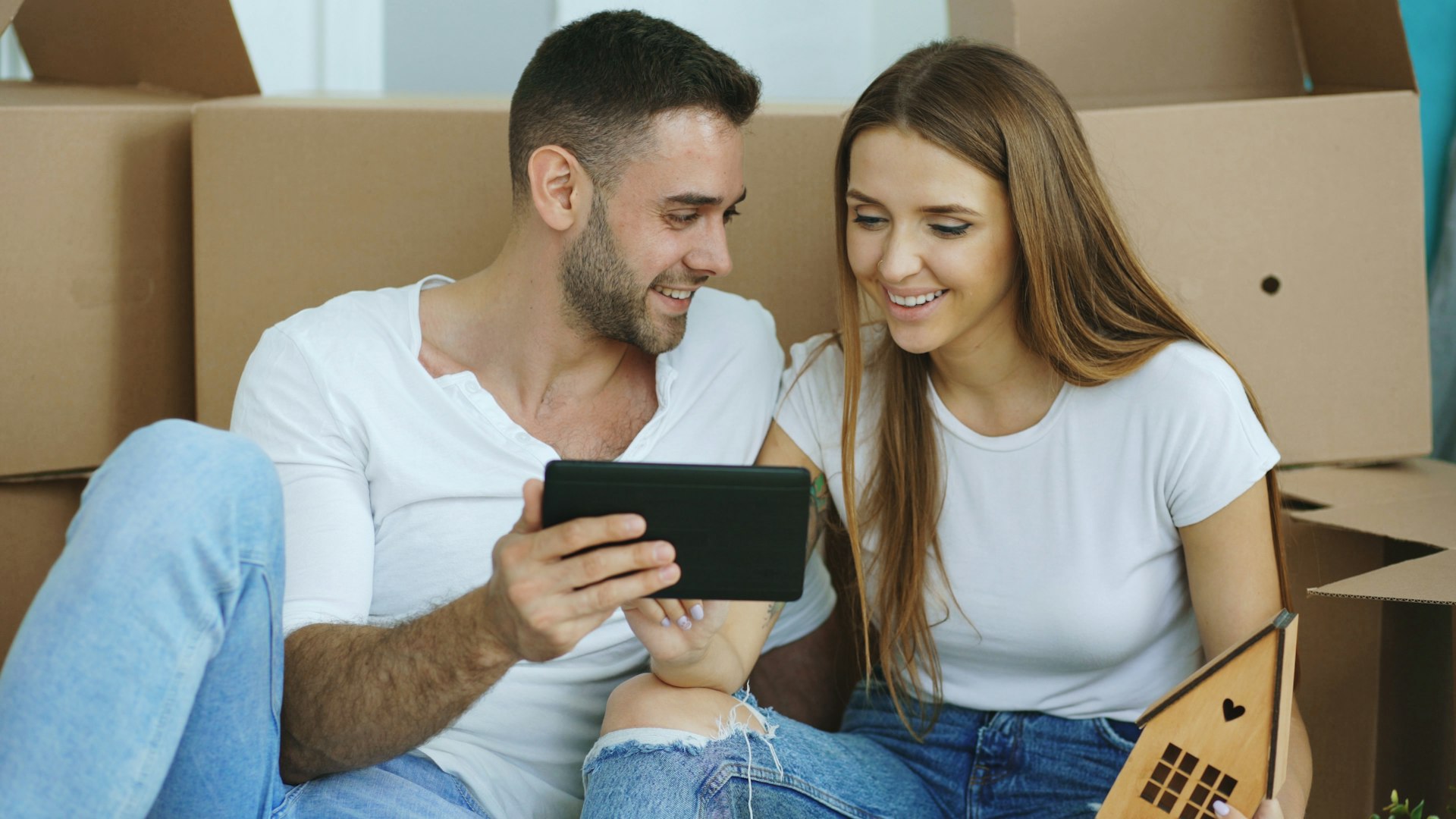 Couple reviewing a tablet together after moving into a new home