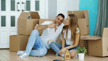 Couple sitting among moving boxes in new home