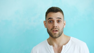 Man with surprised expression against blue background