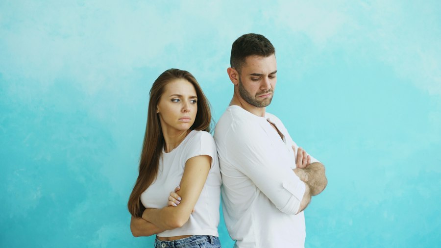 Casal de costas um para o outro, de braços cruzados