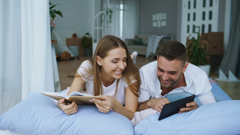 Couple reading in bed happily