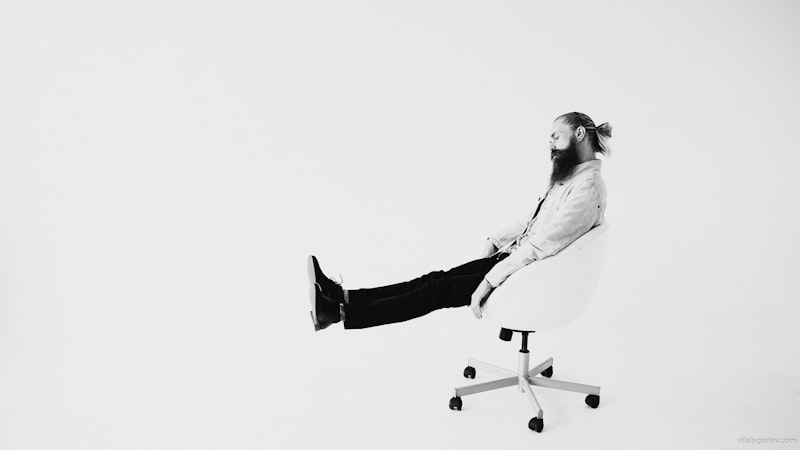 Senior man performing a seated leg stretch from a chair to improve flexibility after 65