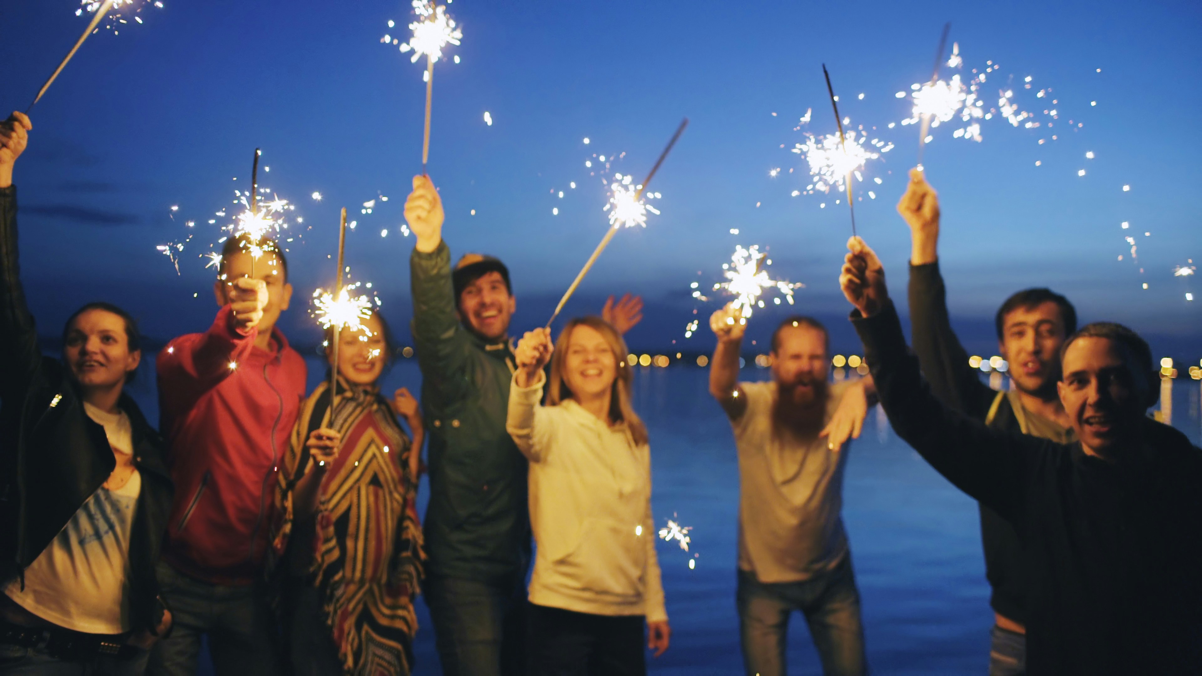 People celebrating with sparklers at night