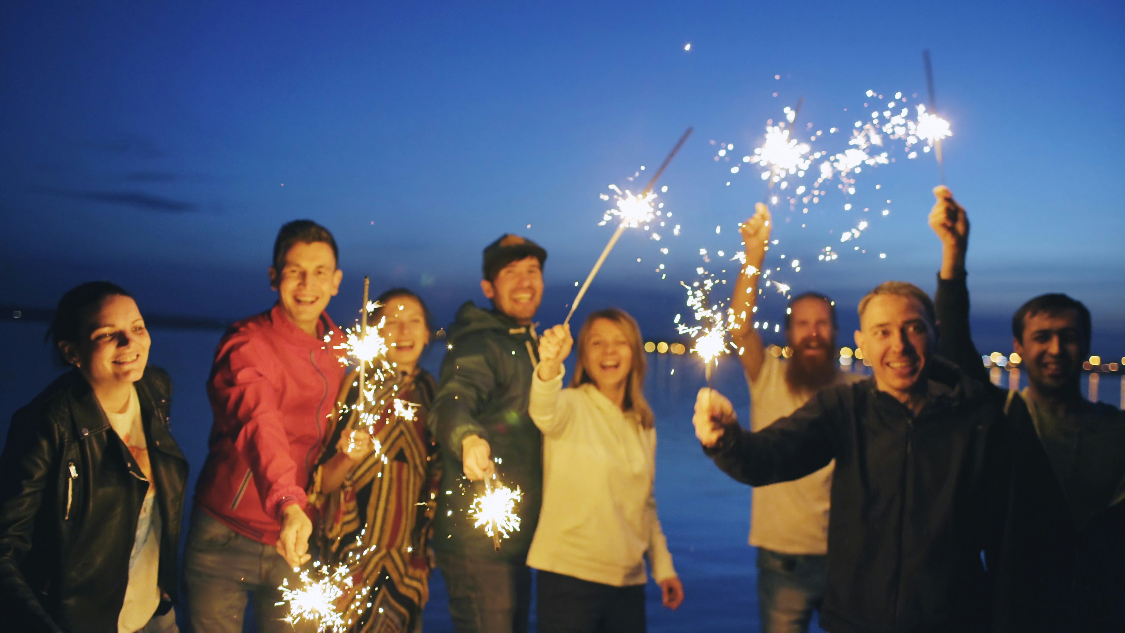 Group of people holding sparklers at night