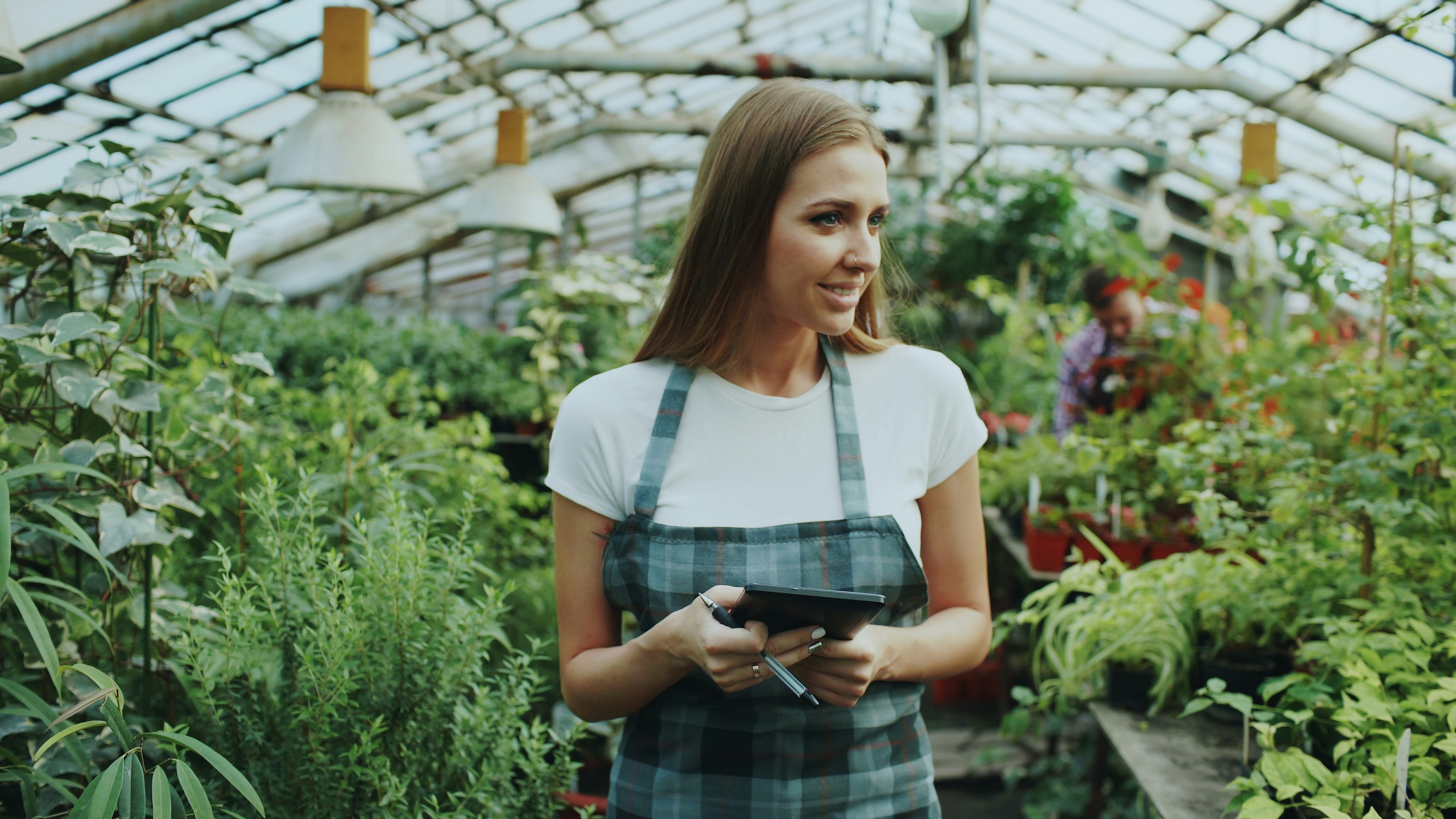Farmer using digital tablet in greenhouse