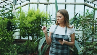 Woman working in a greenhouse with plants