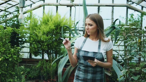 Woman working in a greenhouse with plants