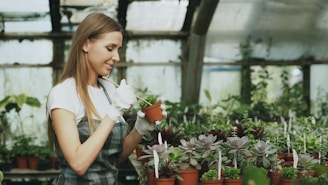 Woman tending to potted plants in a greenhouse