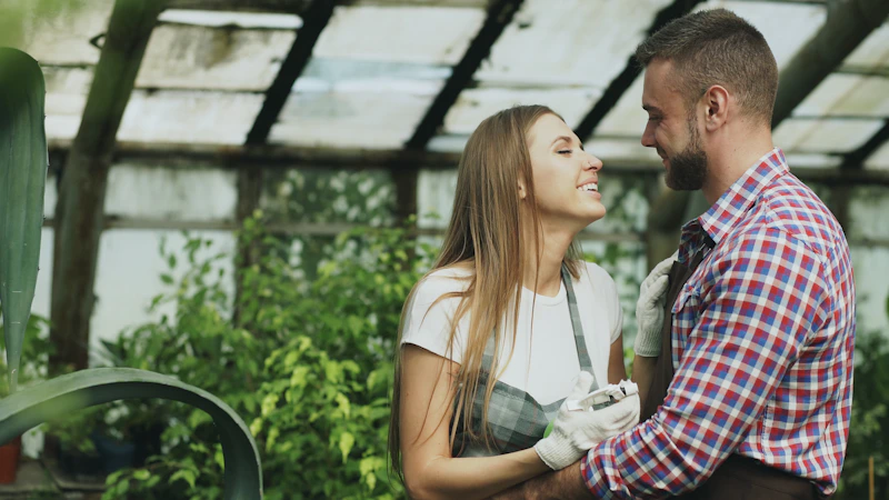 pareja abrazándose en un invernadero con plantas