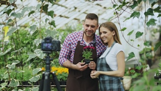 Couple posing with plant in greenhouse