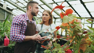 Two people examining plants in a greenhouse.