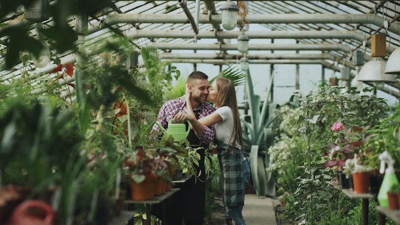 Couple embracing in a lush greenhouse surrounded by plants