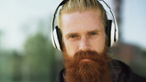 Man with beard and headphones looking at camera