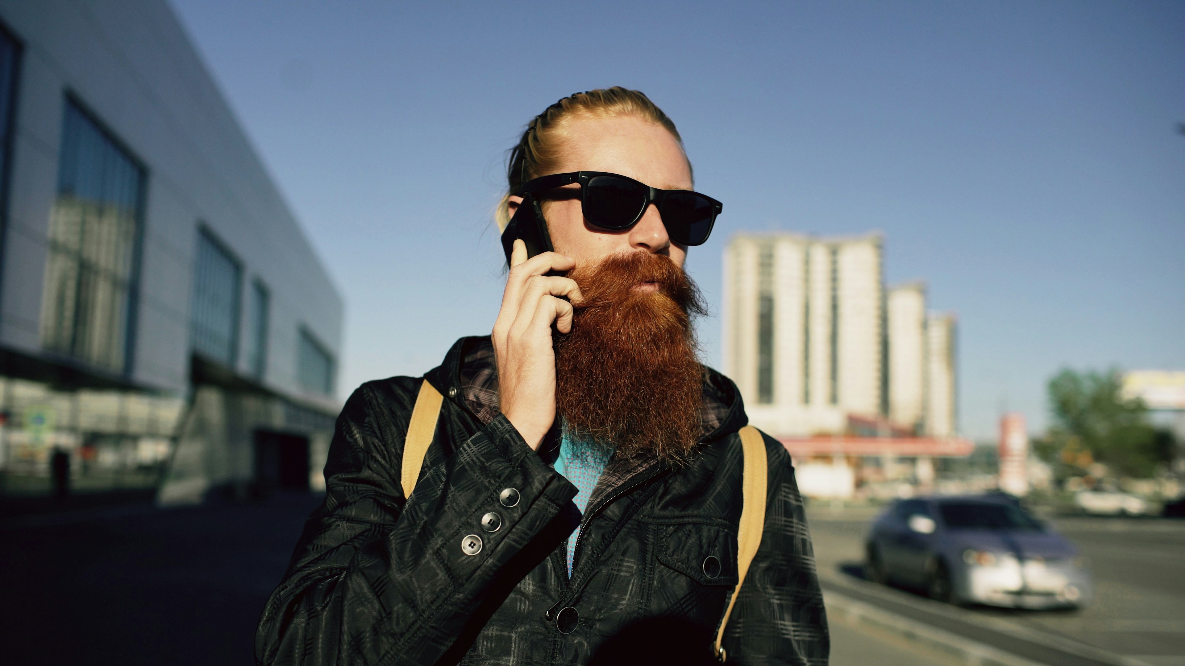Young bearded hipster man using smartphone while exploring