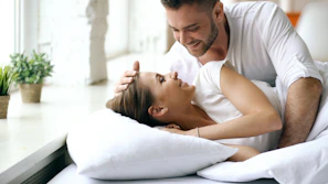 Couple in bed looking at each other lovingly