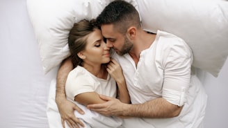 Couple embracing in bed with eyes closed
