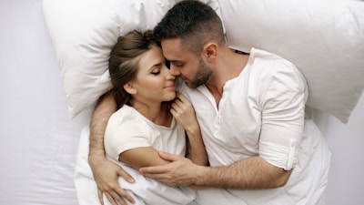 Couple embracing in bed with eyes closed