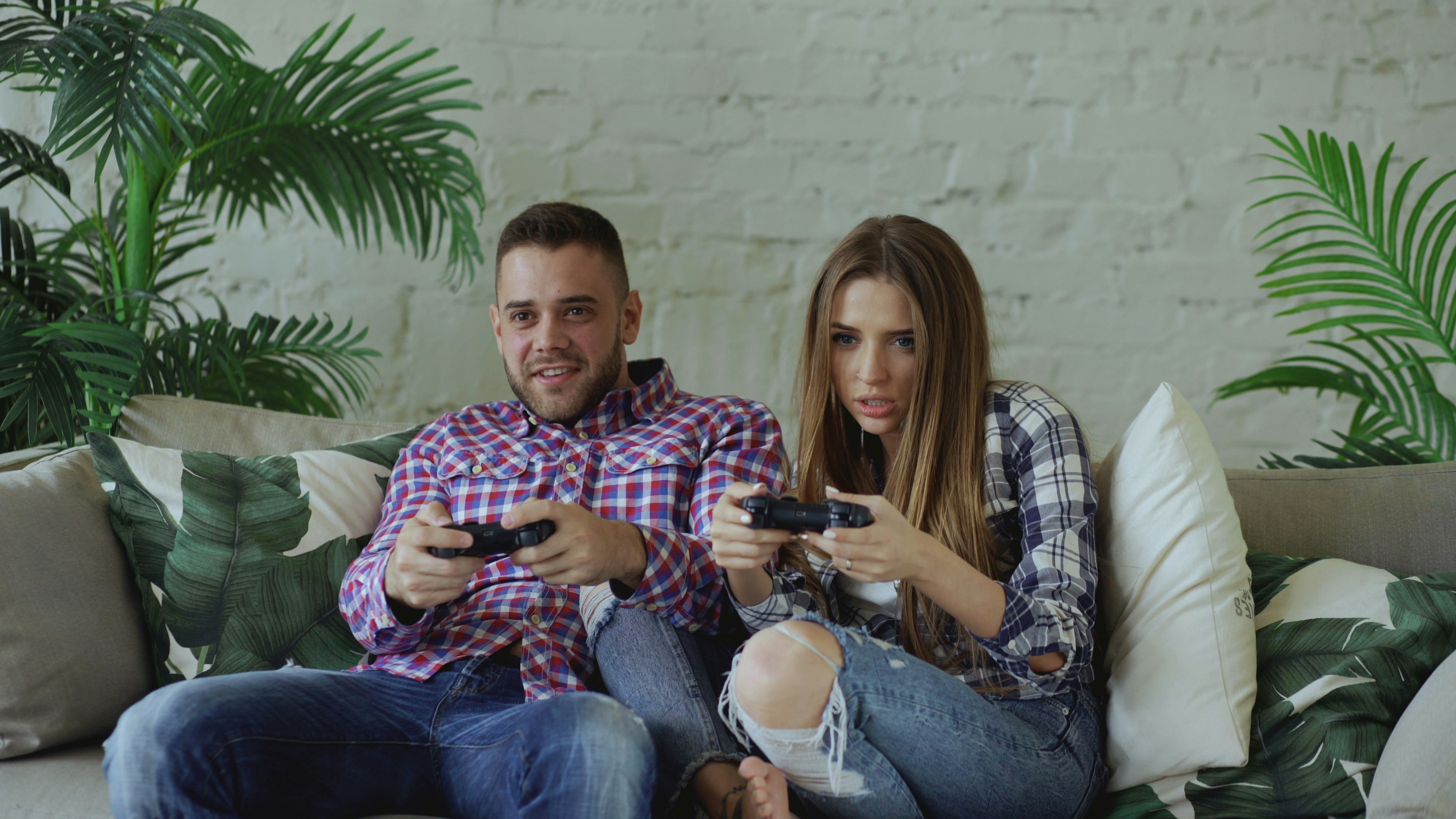Couple playing video games on sofa