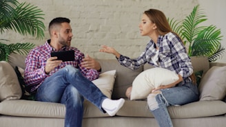 Couple arguing while sitting on a sofa