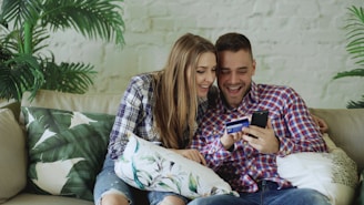 Couple happily shopping online with credit card.