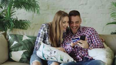 Couple happily shopping online with credit card.