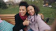 Two smiling women taking a selfie on a park bench.