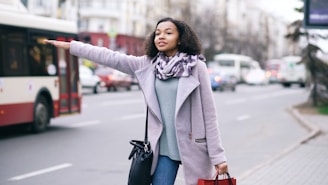 Woman hailing a bus on a city street