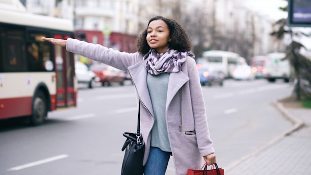Woman hailing a bus on a city street