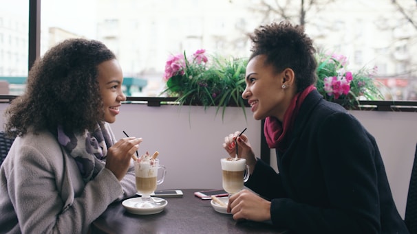 Two women enjoying coffee at a cafe.