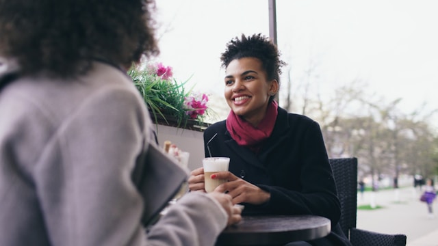 Two women talking at a cafe table