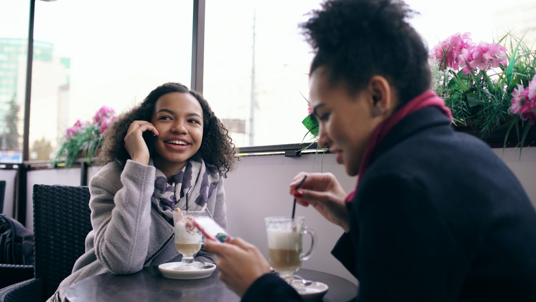 Two women talking at a cafe with coffee